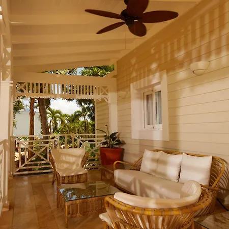 Bahia Principe Luxury Cayo Levantado - All Inclusive Samaná Exterior foto The photo shows a bright and airy porch or veranda, likely part of a tropical home or resort. The space is furnished for relaxation, featuring a wicker sofa with white cushions, a matching wicker armchair, and a small glass-topped coffee table. 

The