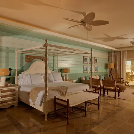 Bahia Principe Luxury Cayo Levantado - All Inclusive Samaná Interior foto This is a bright and airy bedroom with a distinctly tropical feel. The focal point is a large, white four-poster bed with a curved headboard, draped with white bedding and accented with a light-colored throw. 

The walls are a combination of light gr