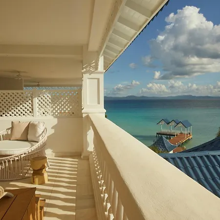 Bahia Principe Luxury Cayo Levantado - All Inclusive Samaná Horizonte foto The photo shows a bright and airy balcony with a stunning ocean view. The balcony is painted a creamy white and features a curved wicker lounge chair with light-colored cushions and two smaller side tables. 

The view is breathtaking: a turquoise oce